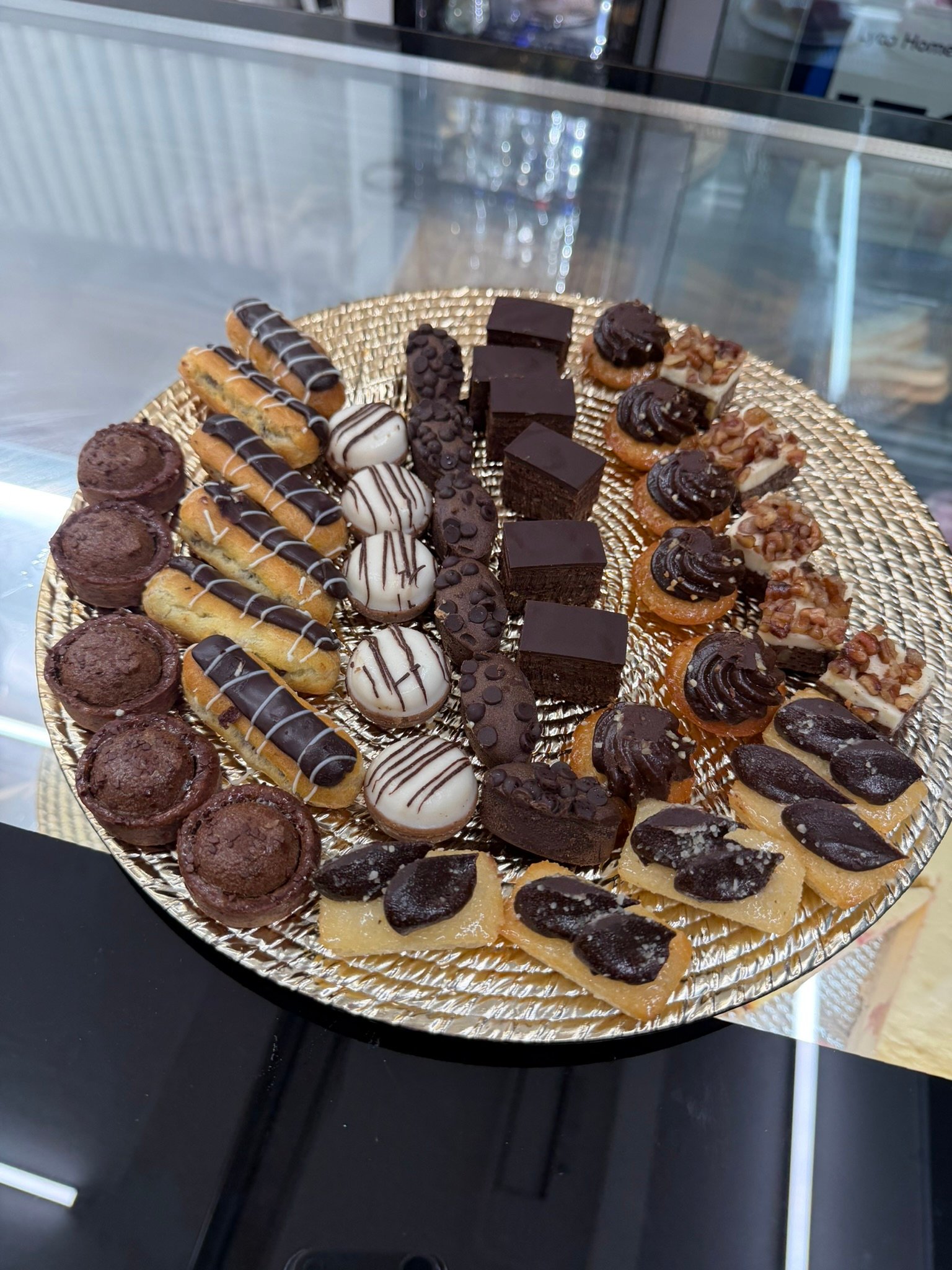 Gemischte Petit Fours auf einem goldenen Servierteller